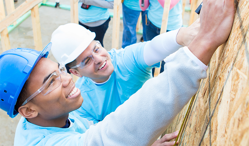 Image of two volunteers building a home.